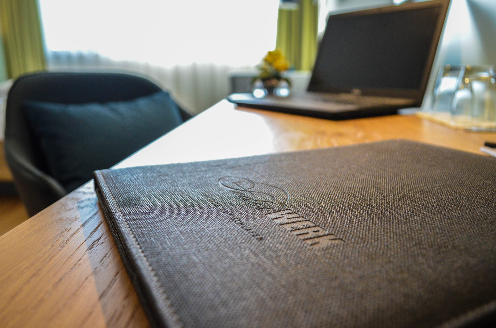 Federwerk Karte auf Schreibtisch im Hotelzimmer mit Laptop im Hintergrund